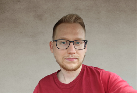 Portret mężczyzny w okularach, z krótkimi blond włosami i zarostem, ubranego w czerwoną koszulkę, pełniącego funkcję Senior Node.js Developer w itCraft.