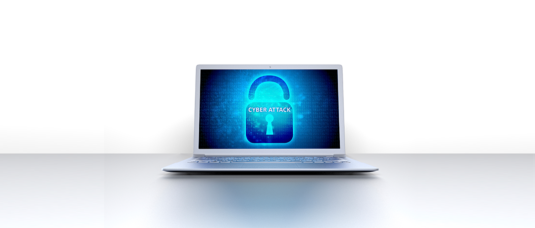 Otwarty laptop na jasnym tle z niebieskim ekranem przedstawiającym ikonę kłódki oraz napisem "Cyber Attack", ilustrujący artykuł itCraft o bezpieczeństwie danych medycznych.